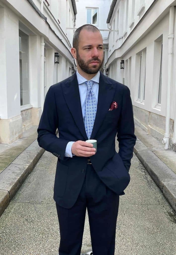 Homme en costume bleu marine dans un couloir moderne
