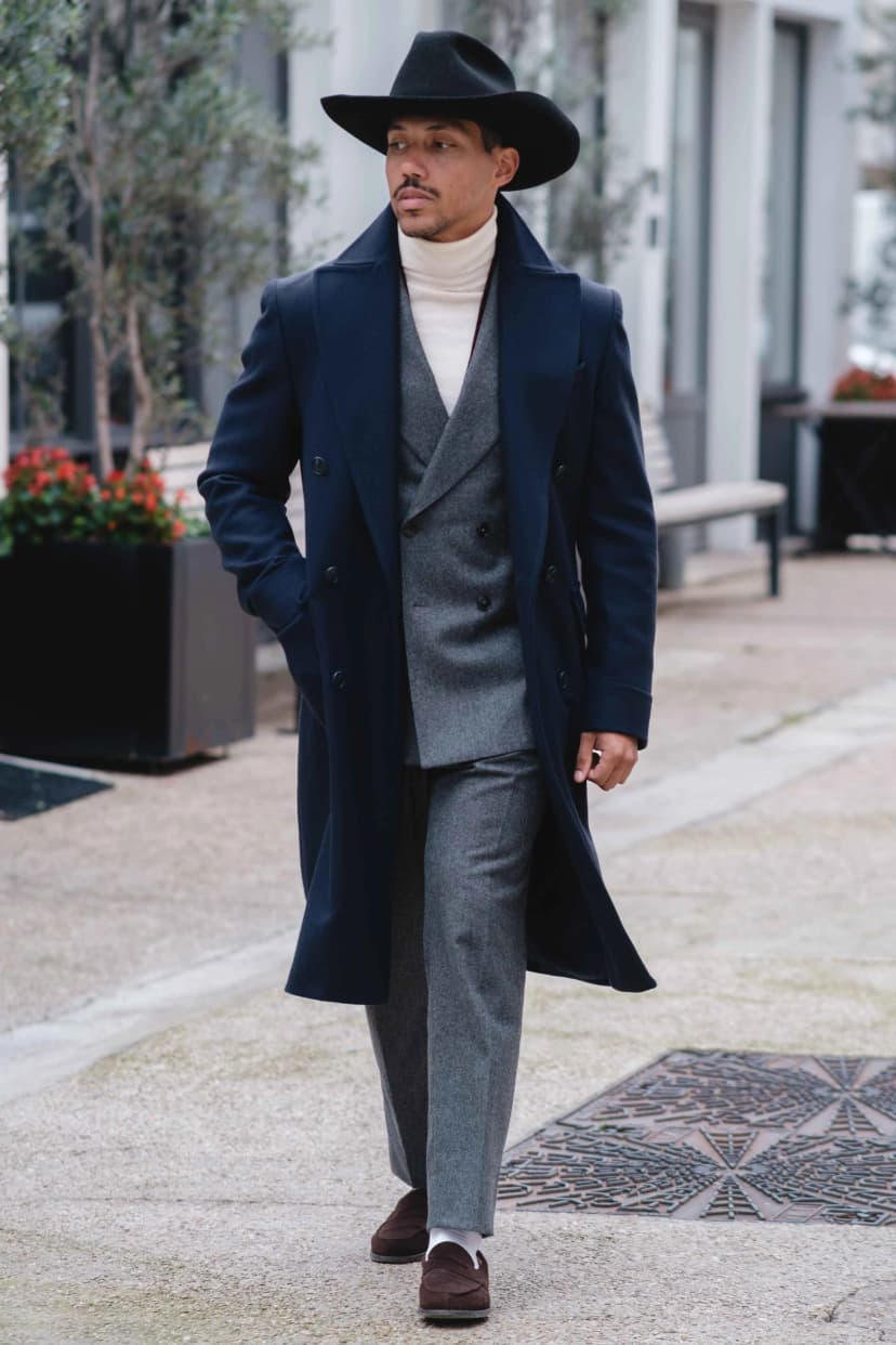 Homme élégant en manteau bleu marine avec chapeau