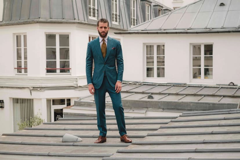 Homme en costume vert sur un toit parisien