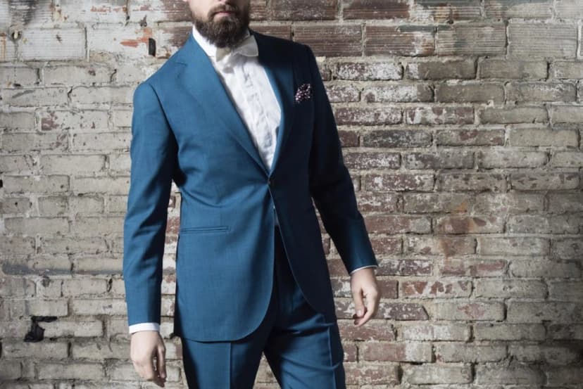 Homme en costume bleu canard avec noeud papillon